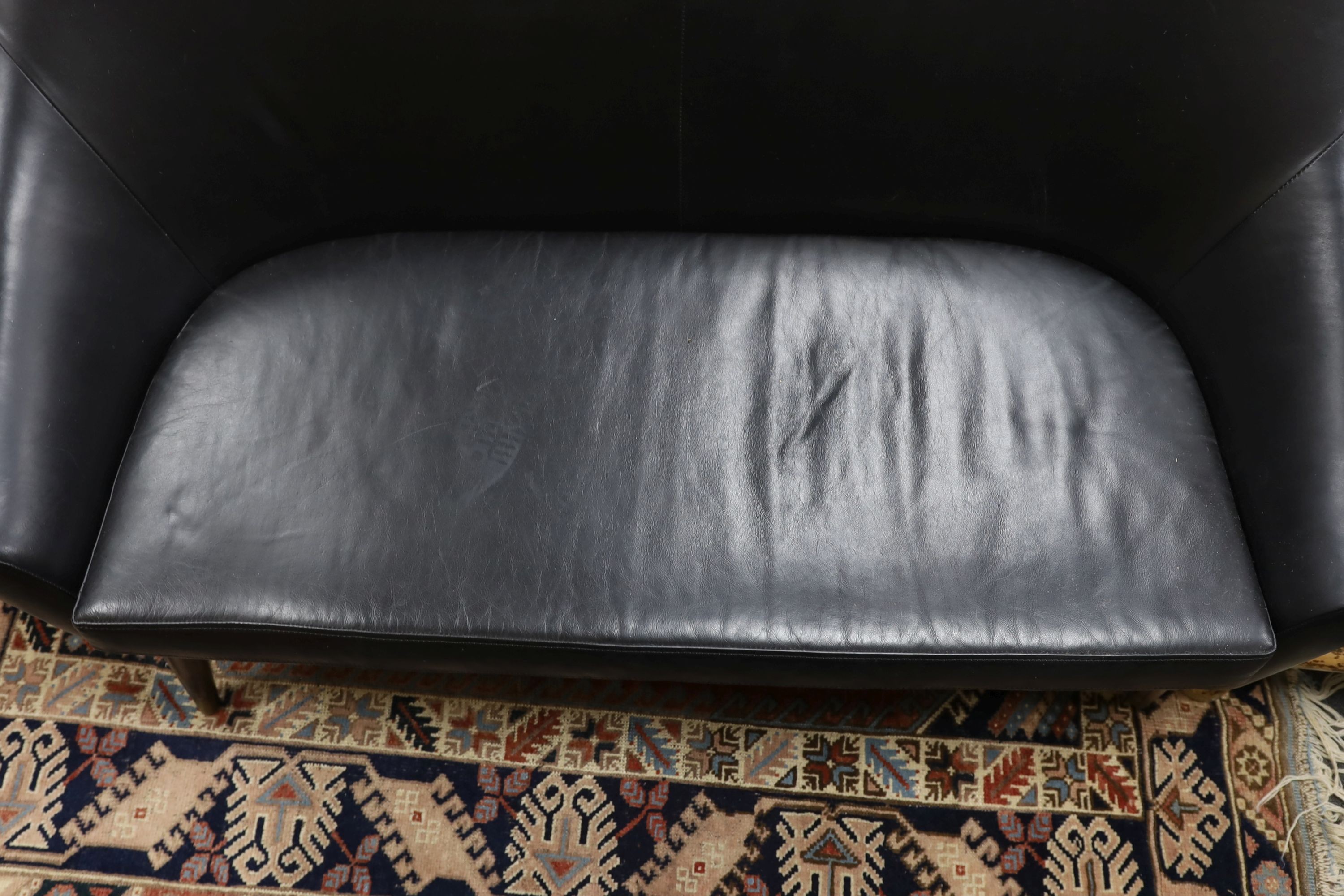 A mid century design black leather tub framed settee, length 136cm, depth 76cm, height 89cm